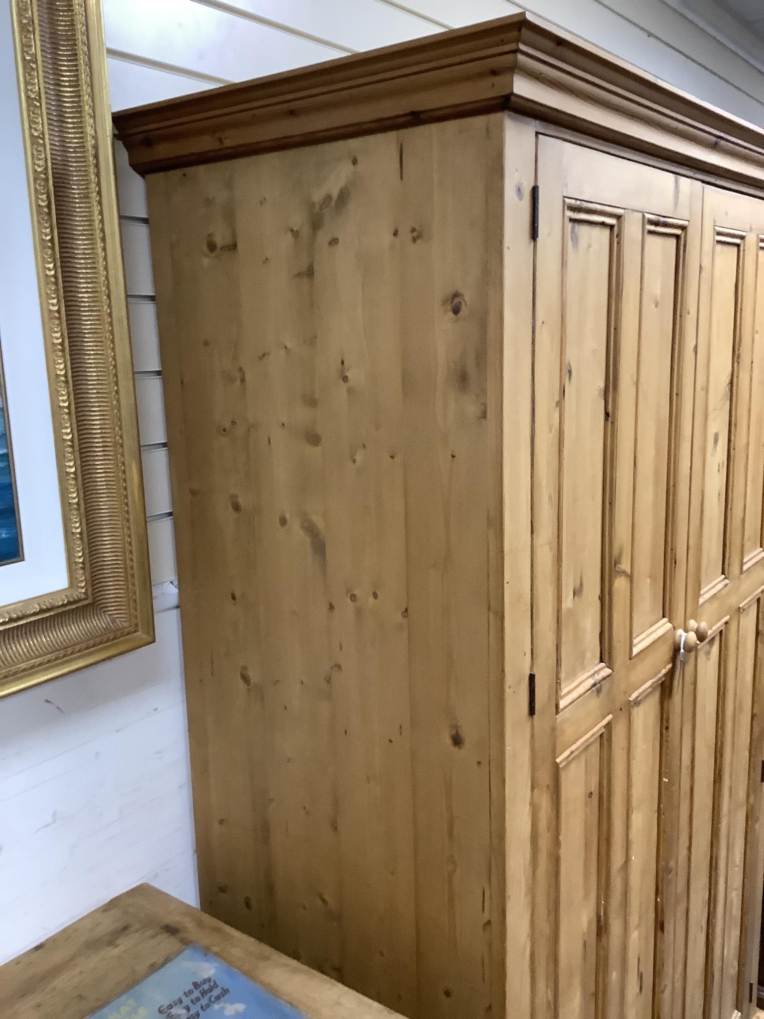 A panelled pine two door wardrobe, length 124cm, depth 59cm, height 197cm
